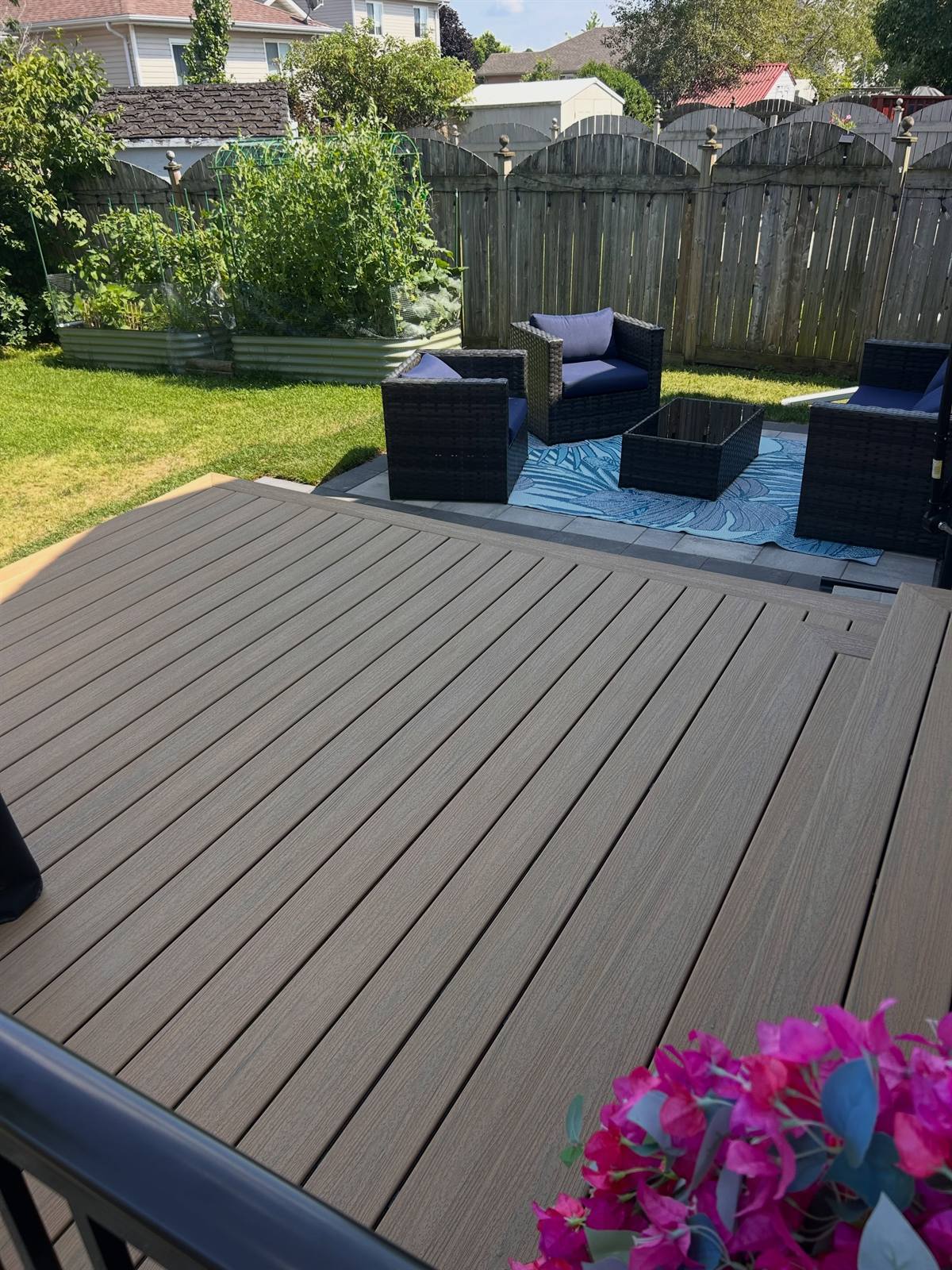 Low-maintenance deck with lounge furniture beside a backyard garden, Kingston area