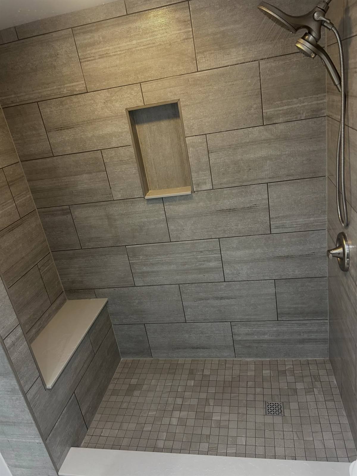 Custom tiled shower with bench and niche in a Kingston-area bathroom renovation