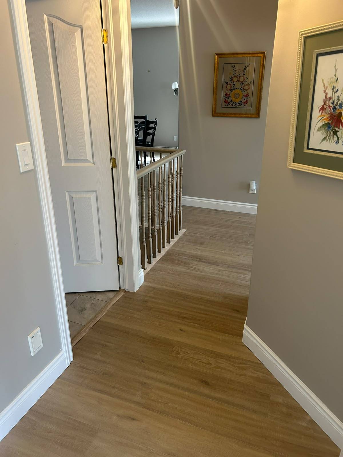 New plank flooring in an upstairs hallway with wood railing in Kingston, Ontario