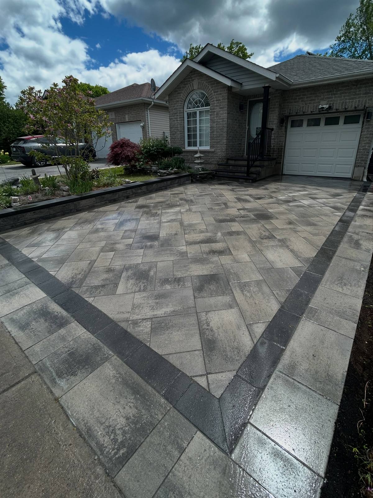 Herringbone interlock driveway with charcoal soldier-course border by Gonzo Construction, Kingston area