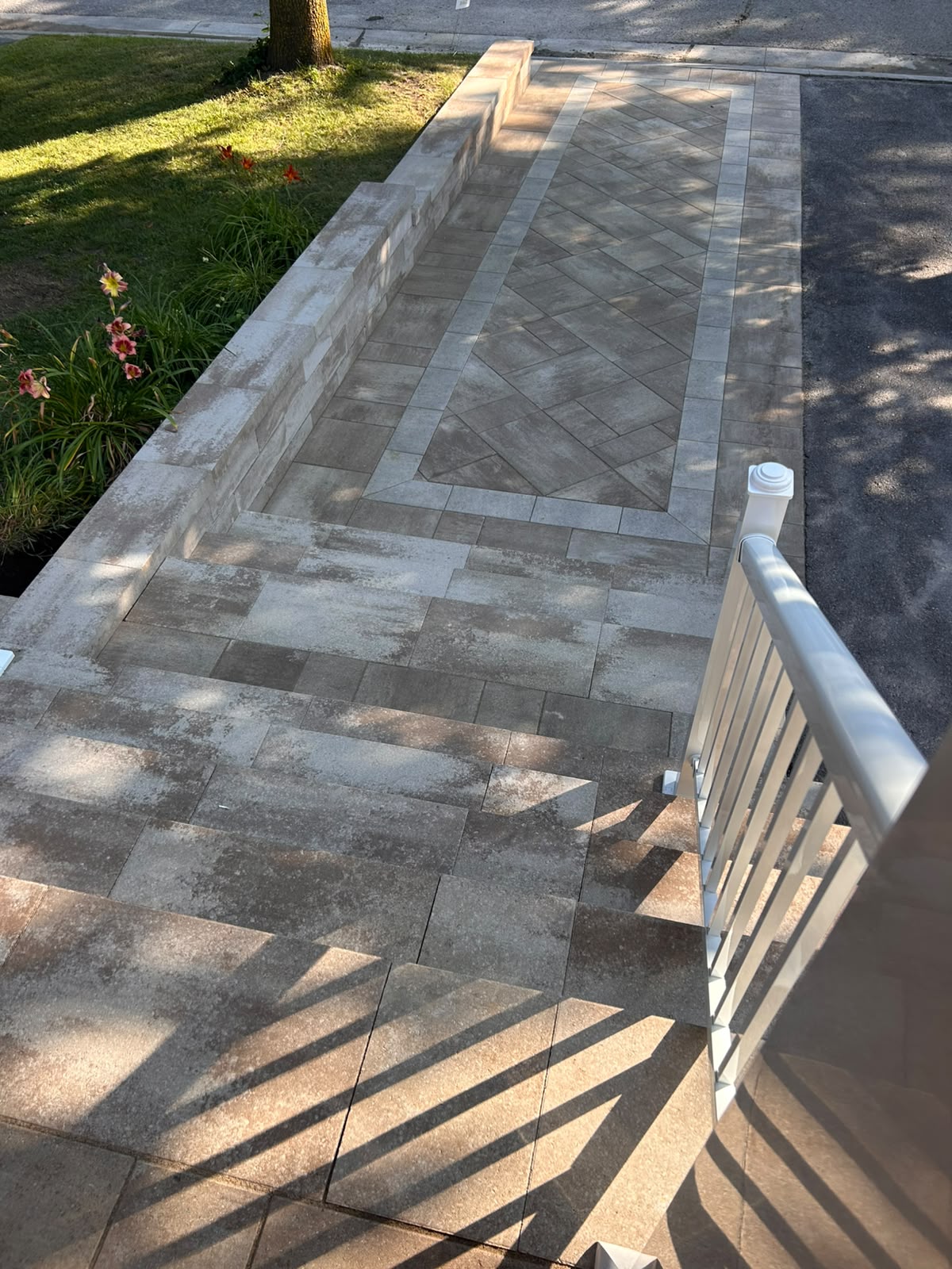 Milano interlock walkway with a herringbone-and-diamond inlay framed by a contrasting border course in Kingston, Ontario