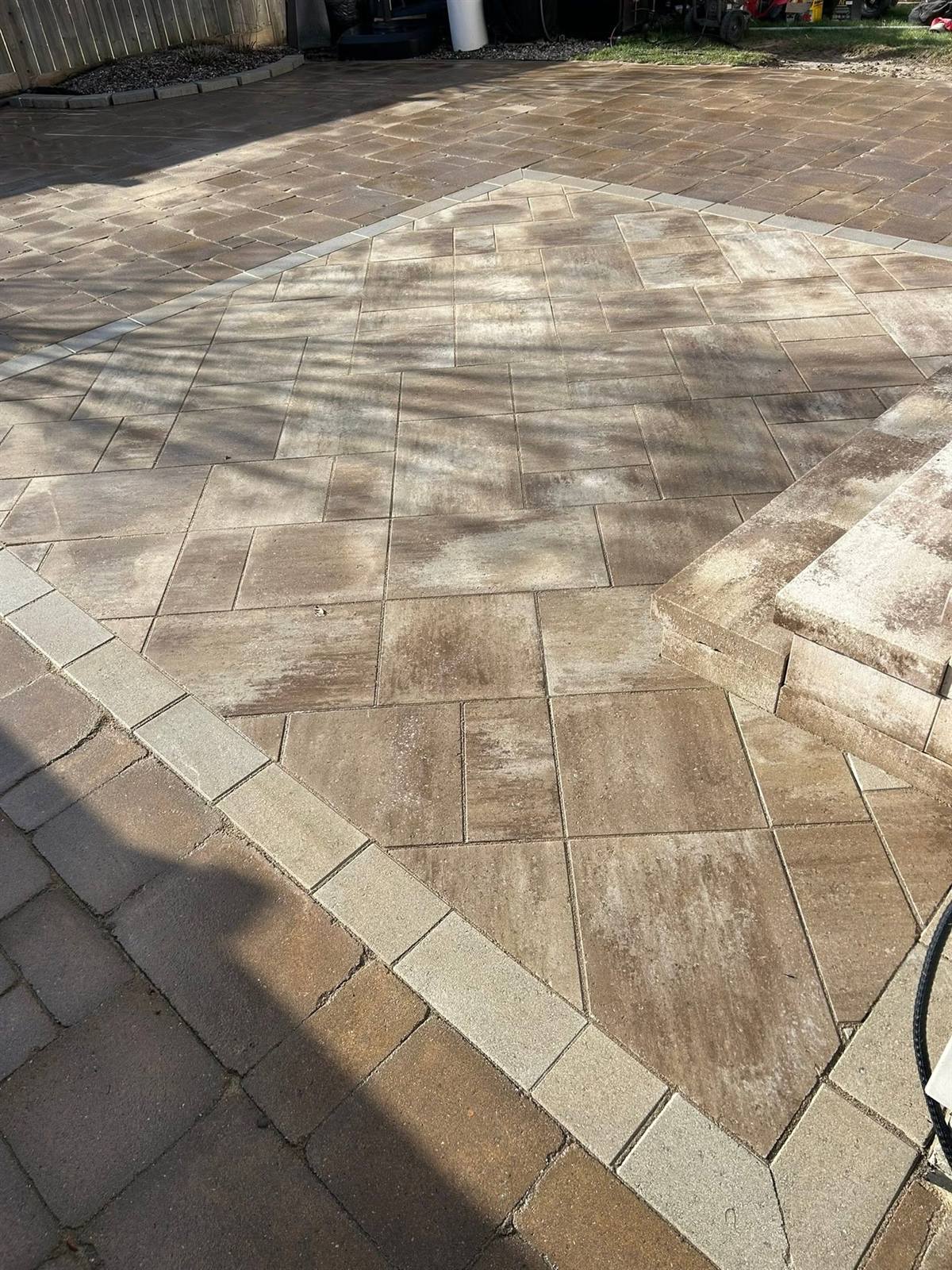 Tan interlock patio laid on the diagonal with a light border course by Gonzo Construction, Kingston area