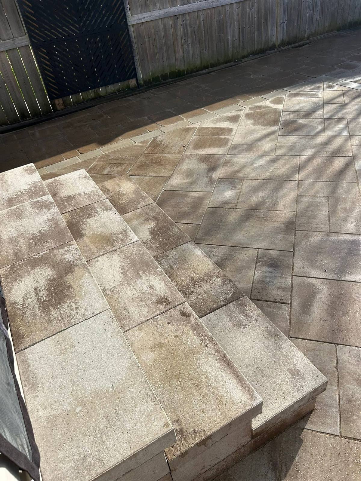 Tan interlock patio with matching stone steps and light soldier-course border by Gonzo Construction, Kingston area